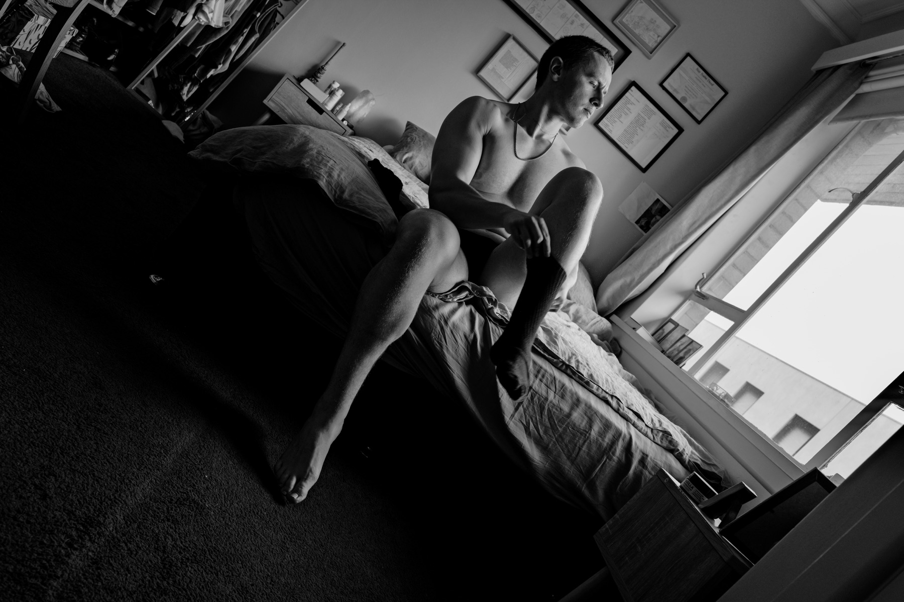 Actor sitting on a bed during a morning routine