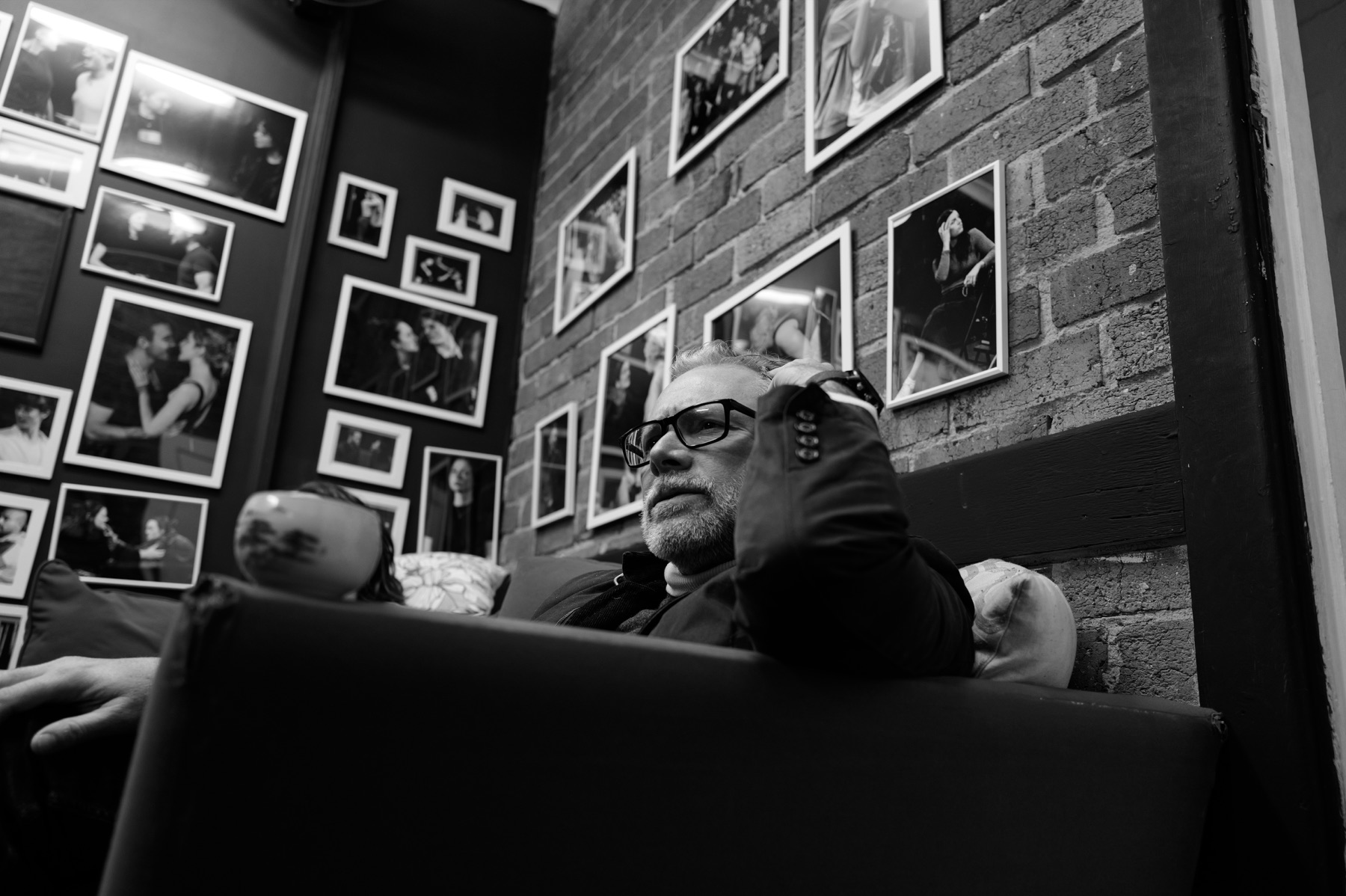 Hamlet rehearsal photograph against a wall of framed images